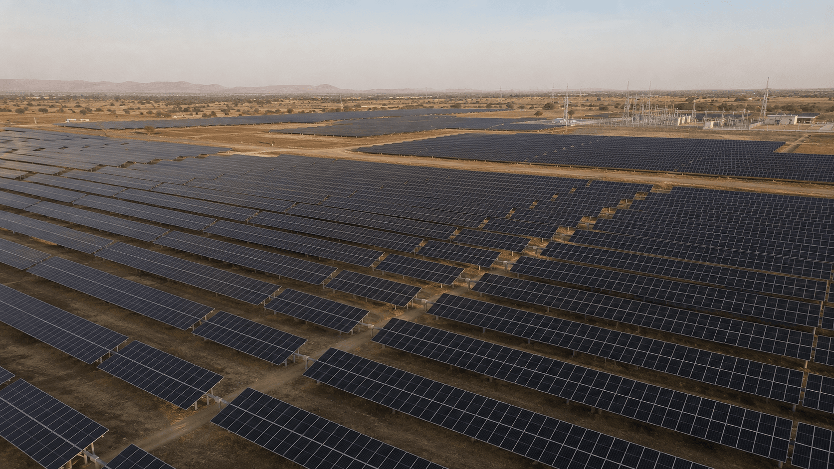 Illustrative scene: rows of utility-scale solar modules across an arid plain under a hazy sky